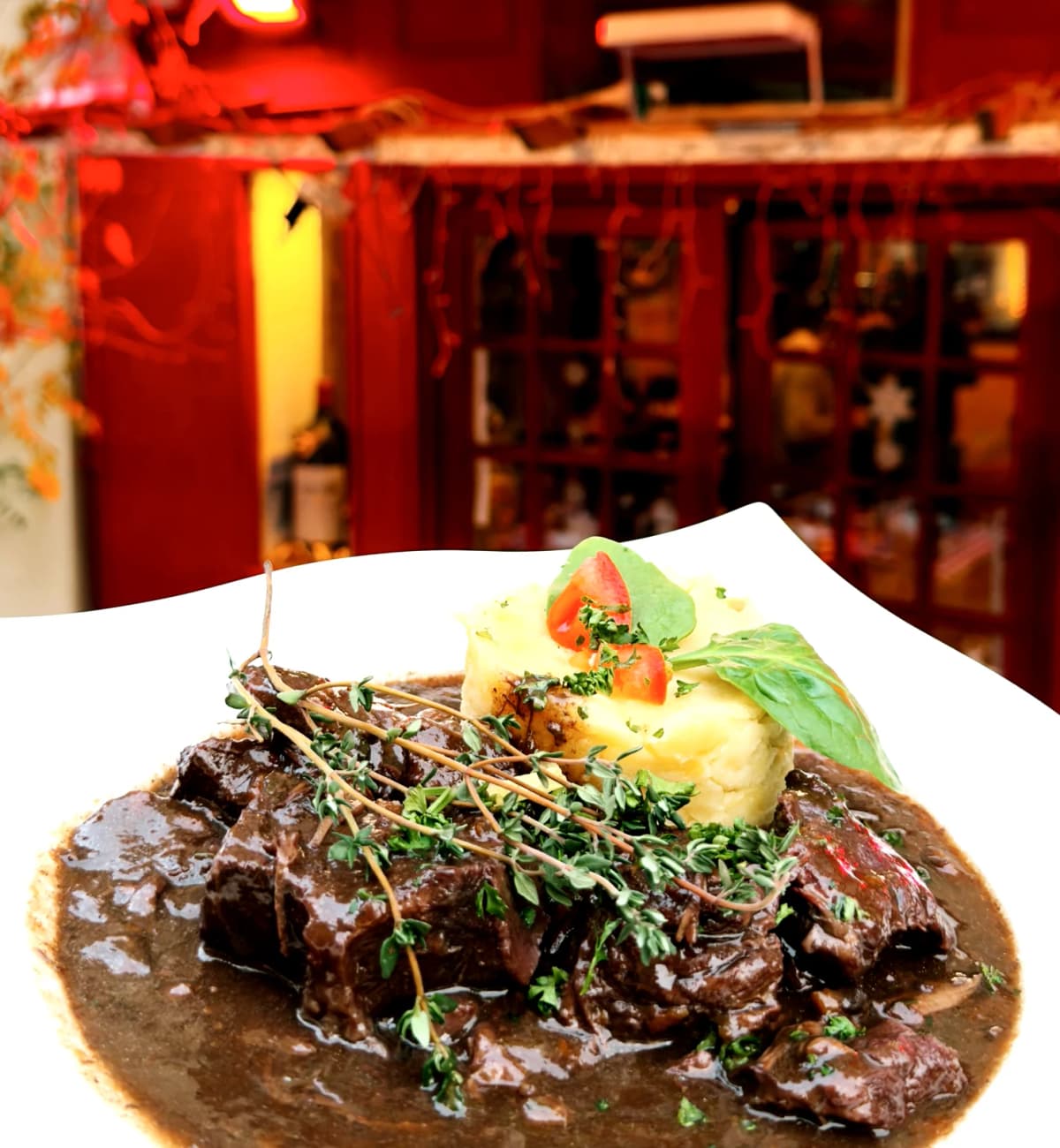 Plat de viande grillée avec frites et salade servie sur planche en bois